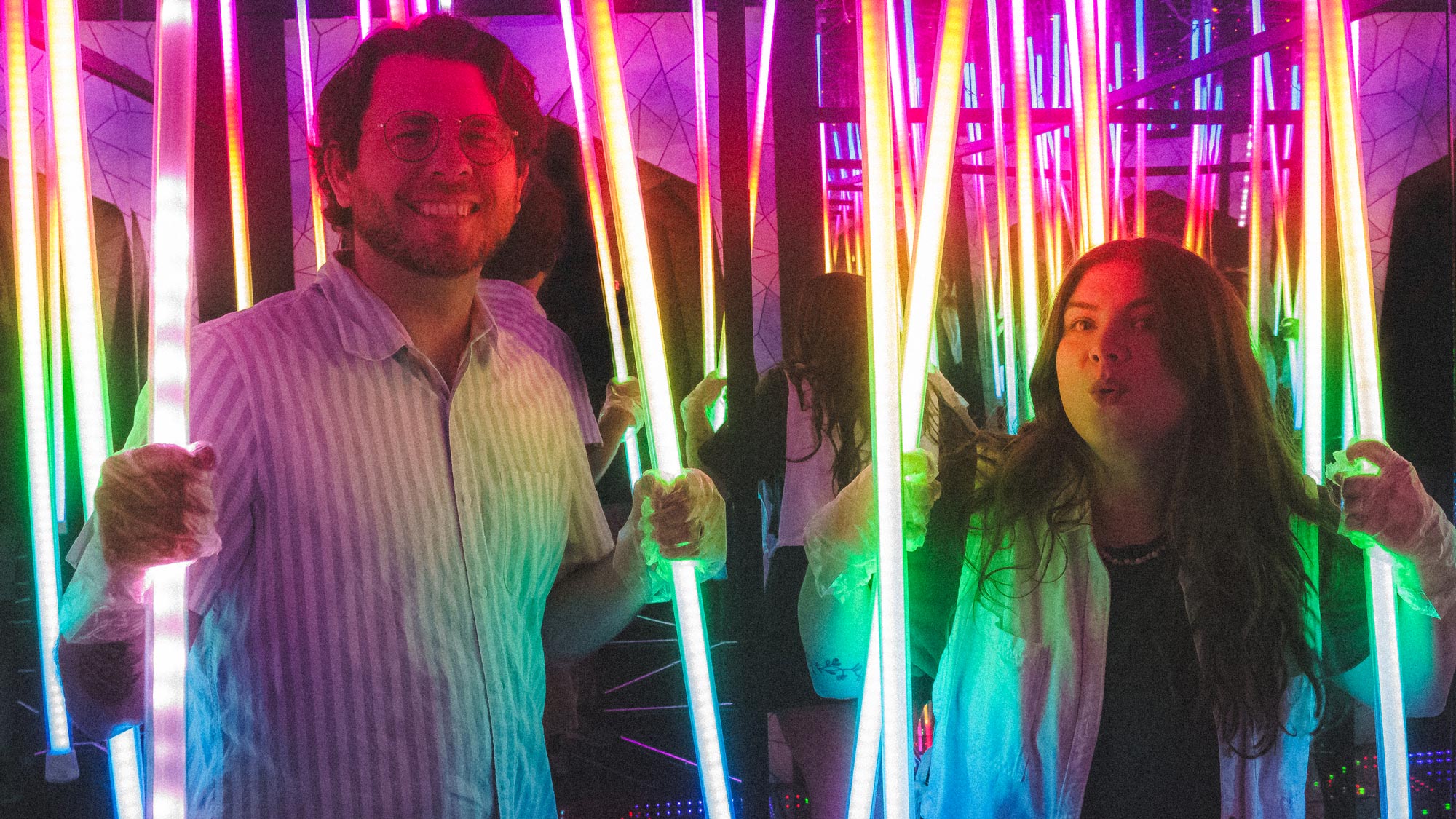 a man and woman holding up neon lights