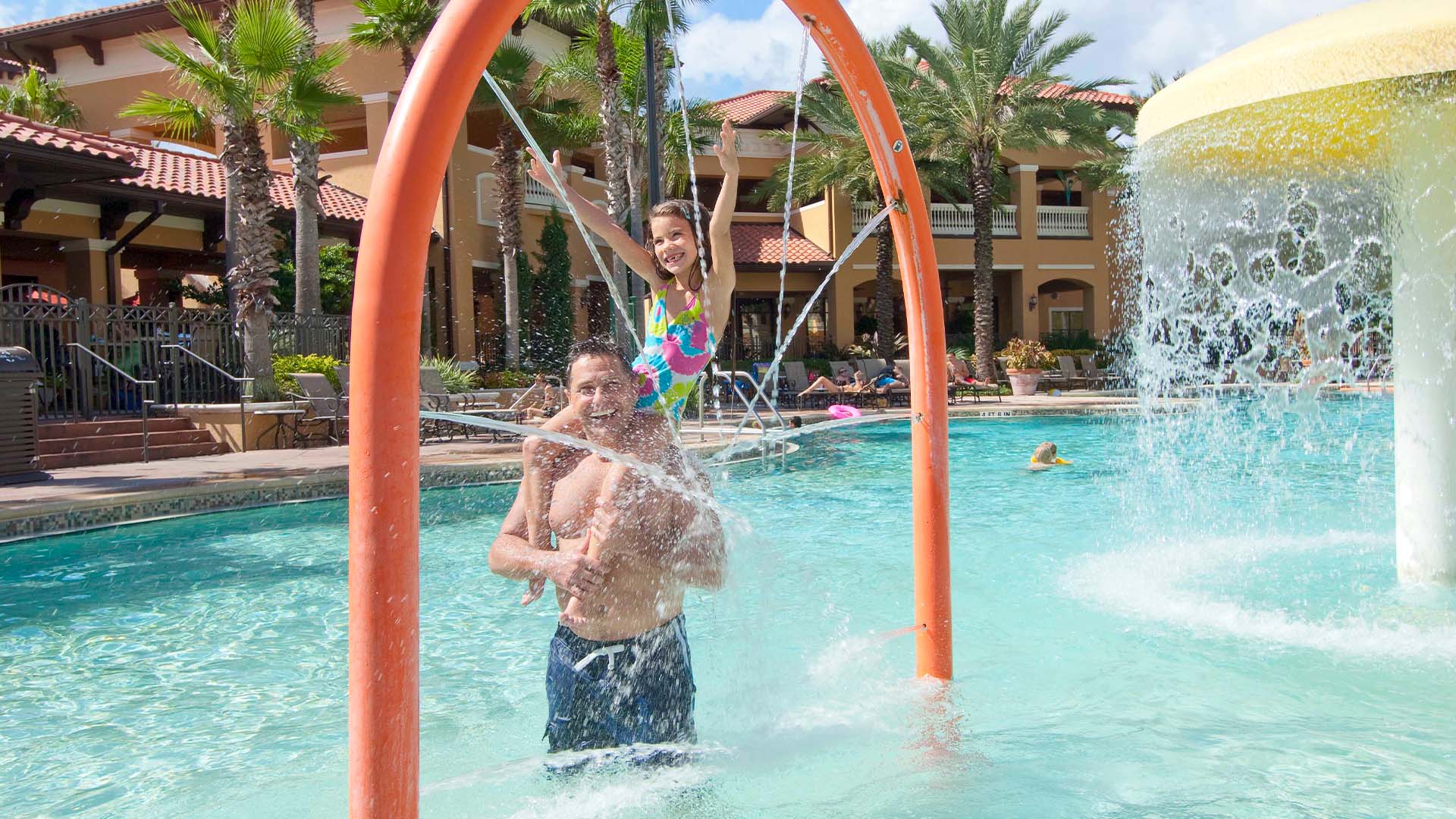 dad holding daughter in the pool